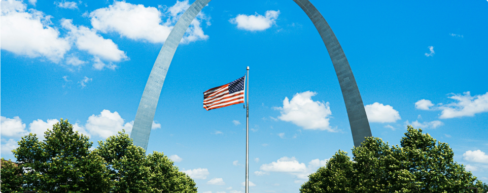 American Flag between two trees and an arc