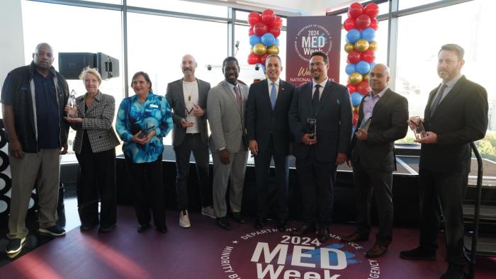 2024 MED Week Award Winners gathered with their awards on stage. 